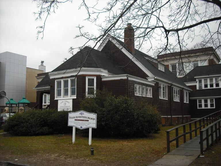 Church building inspected by Checkmark Plus: brown shingle building with sign